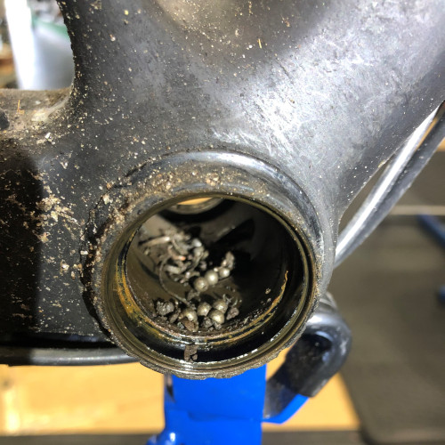 Close-up of ball bearings and metal shavings inside the bottom bracket of a bicycle frame