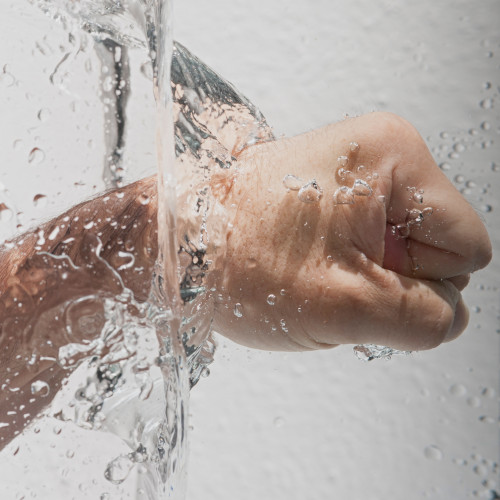 A fist punching through a wall of water