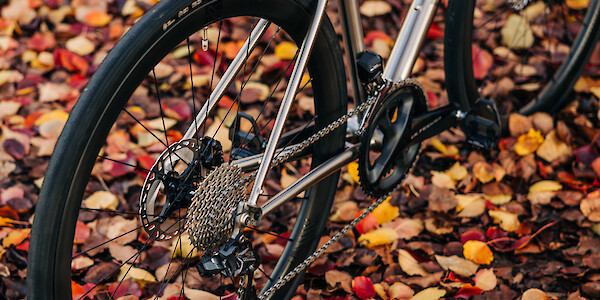 Gear details on a Bossi Strada titanium road bike against a backdrop of autumn leaves