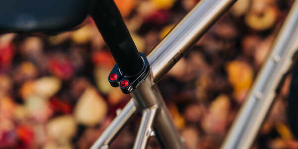 Seat clamp detail with red inserts on a Bossi Strada titanium road bicycle