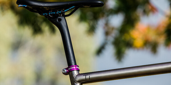 An SQ-Lab, carbon Bossi seat post and purple Hope seat post clamp fitted to a titanium Bossi Grit SX gravel bike, viewed from the side