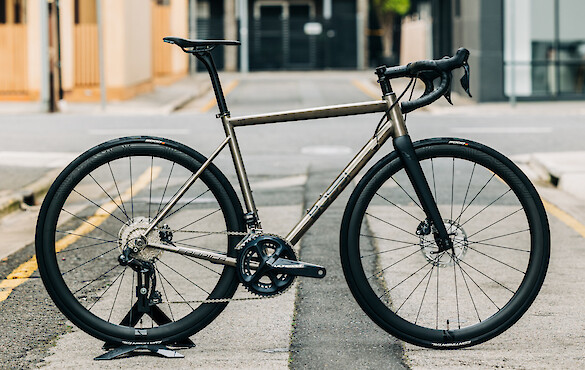 A Bossi Strada titanium road bike in a custom build, standing in a deserted city alleyway
