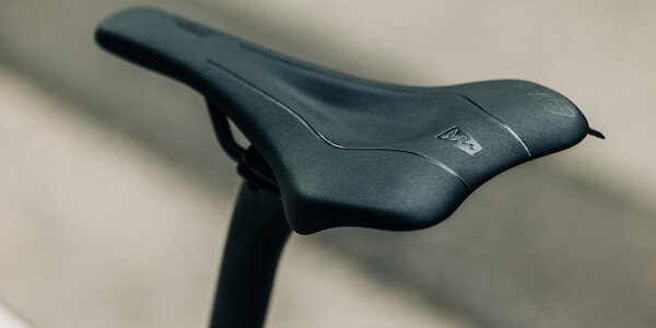An SQ-Lab saddle and carbon Bossi seat post fitted to a titanium bicycle frame, viewed from an upper angle