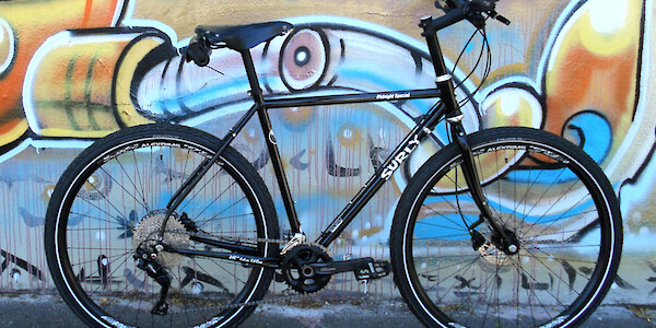 Surly Midnight Special bicycle in a custom build, against a wall of street art