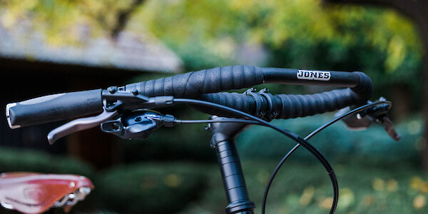 Angled view of a set of Jones Loop handlebars on a Surly Bridge Club bike, a Brooks leather saddle also visible