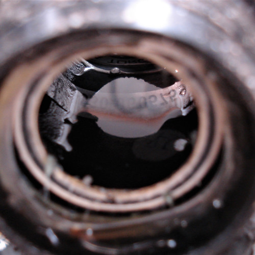 A pool of water inside a bicycle frame's bottom bracket shell.