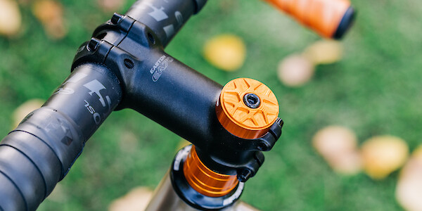 Details on a set of Easton handlebars, Easton headstem, orange Garbaruk top cap and orange Hope headset spacers, fitted to a custom-built Bossi Grit SX titanium gravel bike