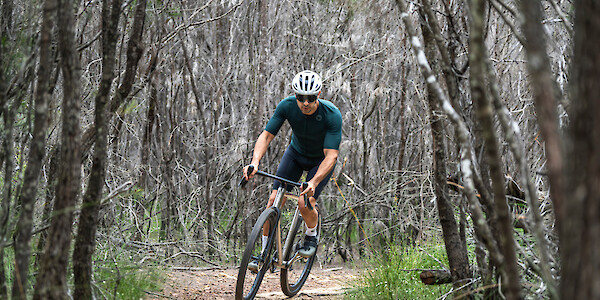 James Bossi of Bossi Bicycles riding a Grit SS titanium gravel bike through the forest. Yes, he's the owner of the company.