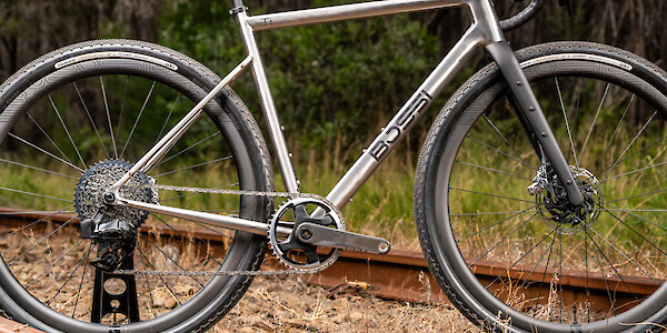 Frame detail on a Bossi Grit SS titanium gravel bike, photographed on train tracks