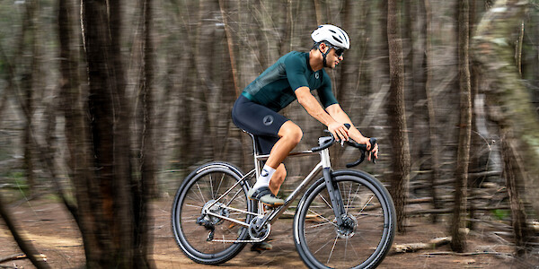 James Bossi riding a Bossi Grit SS titanium gravel bike through the forest. Yes, he's the owner of the company.