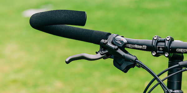 Handlebar detail on a custom-built black Surly Disc Trucker steel touring bike.