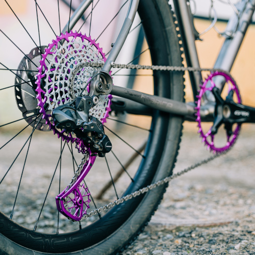 Drivetrain detail of violet Garbaruk gear components, fitted to a titanium gravel bike