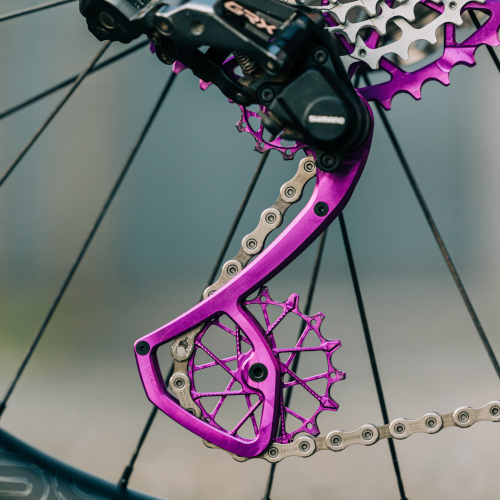 Close-up detail of a violet Garbaruk rear derailleur cage and matching jockey wheels/pulleys
