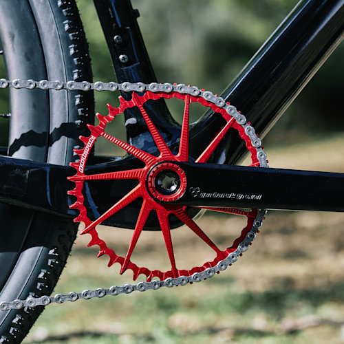 Drivetrain detail of a red Garbaruk chainring, fitted to a carbon Gothic Cycles gravel bike