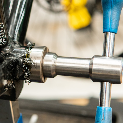 A facing tool sitting in the headtube of a titanium bicycle frame at Bio-Mechanics Cycles & Repairs in South Australia.