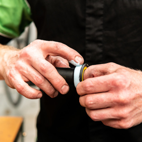 A bicycle bottom bracket being greased in preparation for installation, at Bio-Mechanics Cycles & Repairs in South Australia.