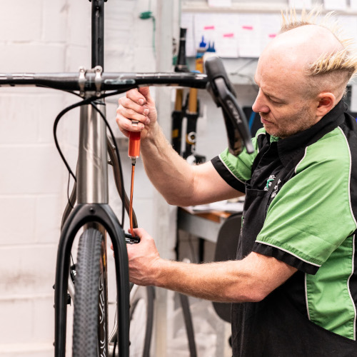 A professional bicycle mechanic bleeding a hydraulic brake at Bio-Mechanics Cycles & Repairs in South Australia.