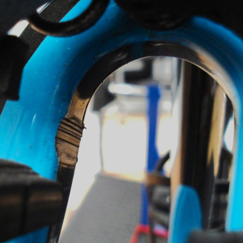 Close-up on a bicycle frame where the tyre has rubbed away a section of the frame.