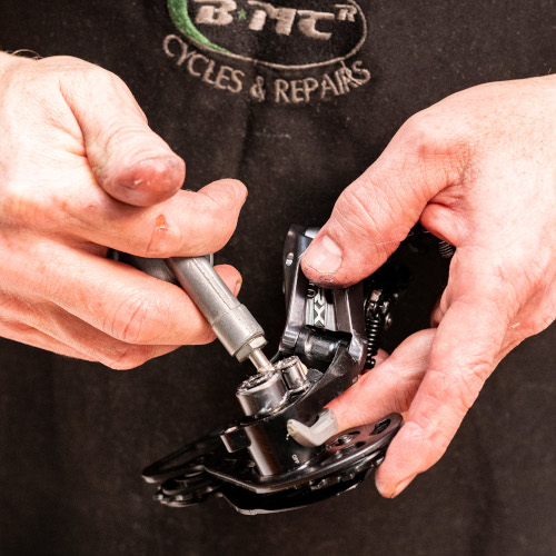 A professional bicycle mechanic servicing a rear derailleur clutch at Bio-Mechanics Cycles & Repairs in South Australia.