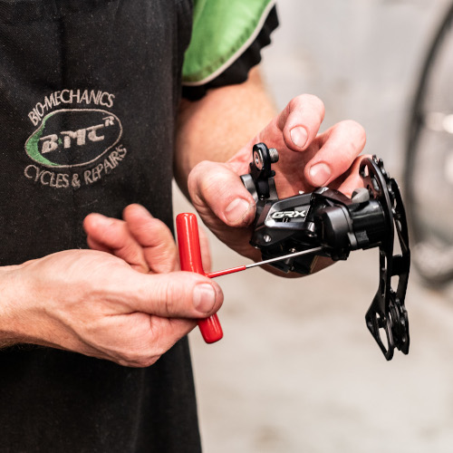 A professional bicycle mechanic servicing a rear derailleur at Bio-Mechanics Cycles & Repairs in South Australia.