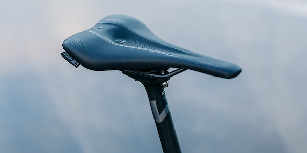 Newmen Advanced carbon bicycle seat post, with a saddle fitted on top.