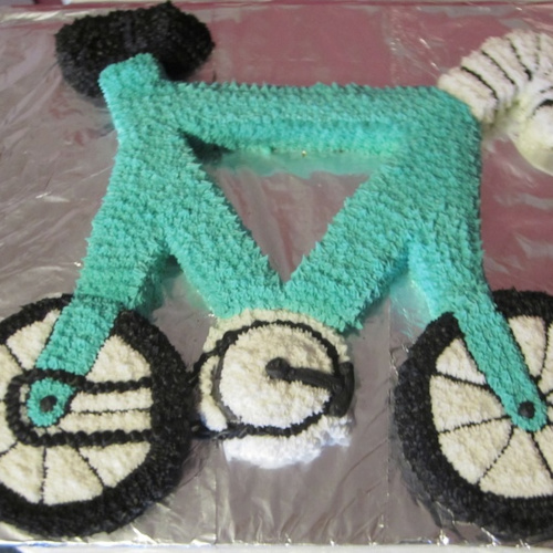 A cake made roughly in the shape of a bicycle.