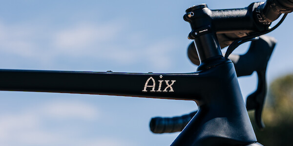 Gothic Cycles Aix carbon gravel bicycle frame detail, created by Bio-Mechanics Cycles & Repairs, focusing on the silver 'Aix' detail.