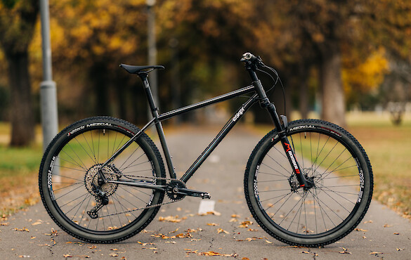 An Esker Hayduke touring mountain bike, custom-built by Bio-Mechanics Cycles & Repairs, shot on a footpath with a leafy autumnal background.