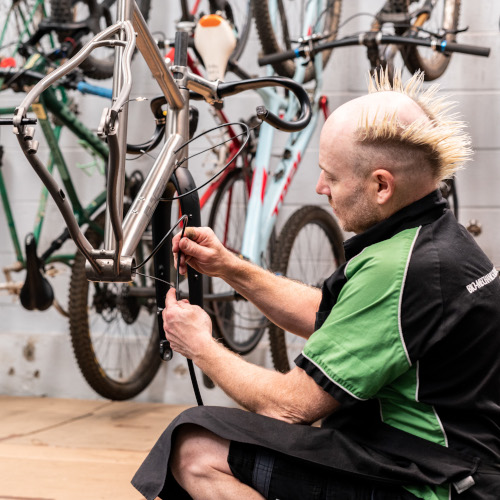 A professional bicycle mechanic working at Bio-Mechanics Cycles & Repairs.