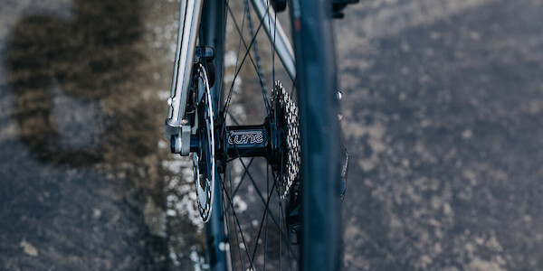 Rear hub detail on a custom-built Bossi Summit titanium road bicycle, photographed on a carpark roof