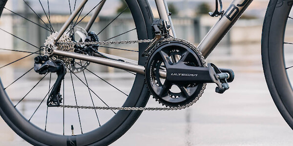 Drivetrain/gear detail on a custom-made Bossi Summit titanium road bicycle, photographed on a roof carpark on a wet and moody day