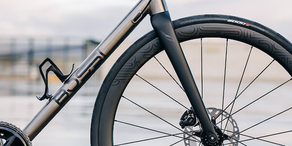 Frame detail on a custom-built Bossi Summit titanium road bicycle, photographed on a roof carpark on a wet and moody day