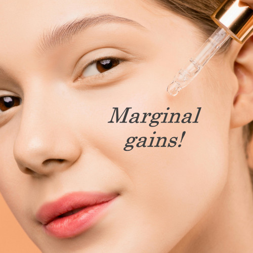 A woman dripping facial serum onto her cheek, with 'marginal gains!' superimposed underneath.