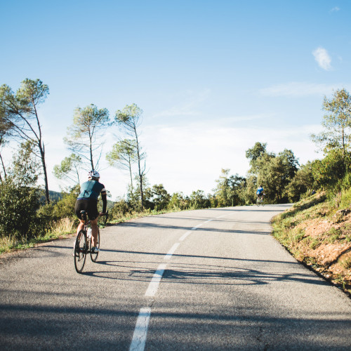 Two cyclists heading up a road into the hills.