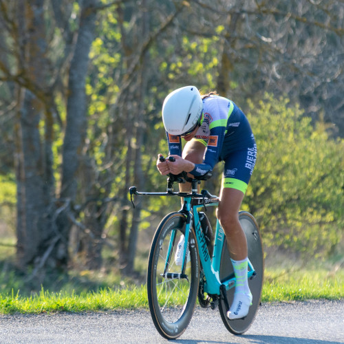 A road cyclist doing a time trial on a country road.