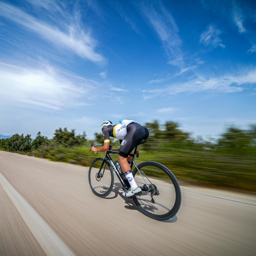 A cyclist descending a road at speed.