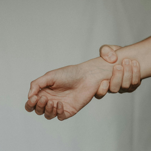 Someone holding their wrist, as if in pain.