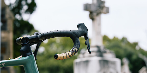 Handlebar detail on a custom-built Gothic Cycles Aix carbon gravel bicycle, photographed in a graveyard