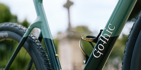 Frame detail (greens and gol) on a custom-built Gothic Cycles Aix carbon gravel bicycle, photographed in a graveyard