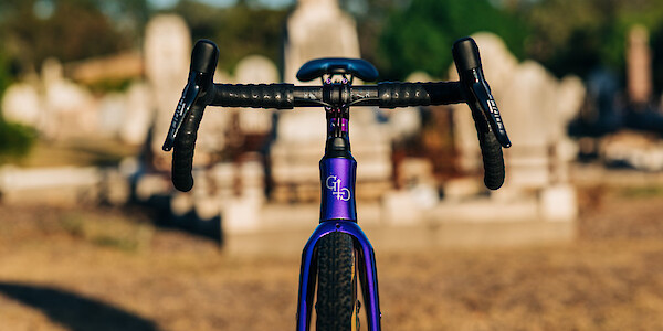 Custom-build Gothic Aix carbon gravel bike in purple and green, front view
