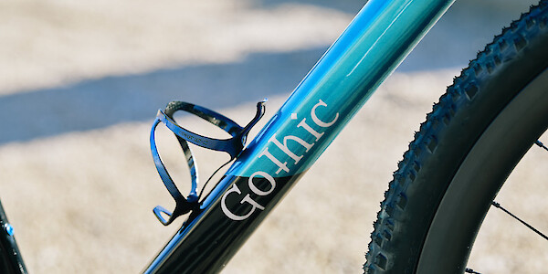 Carbon frame detail on a custom Gothic Cycles gravel bike, fitted with a blue Ciclovation bottle cage