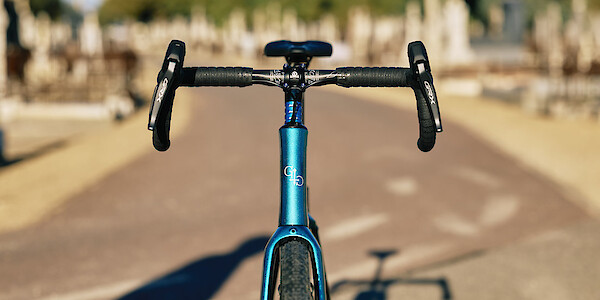 Headtube and handlebar detail on a custom-built carbon Gothic Cycles gravel bike, photographed in a graveyard